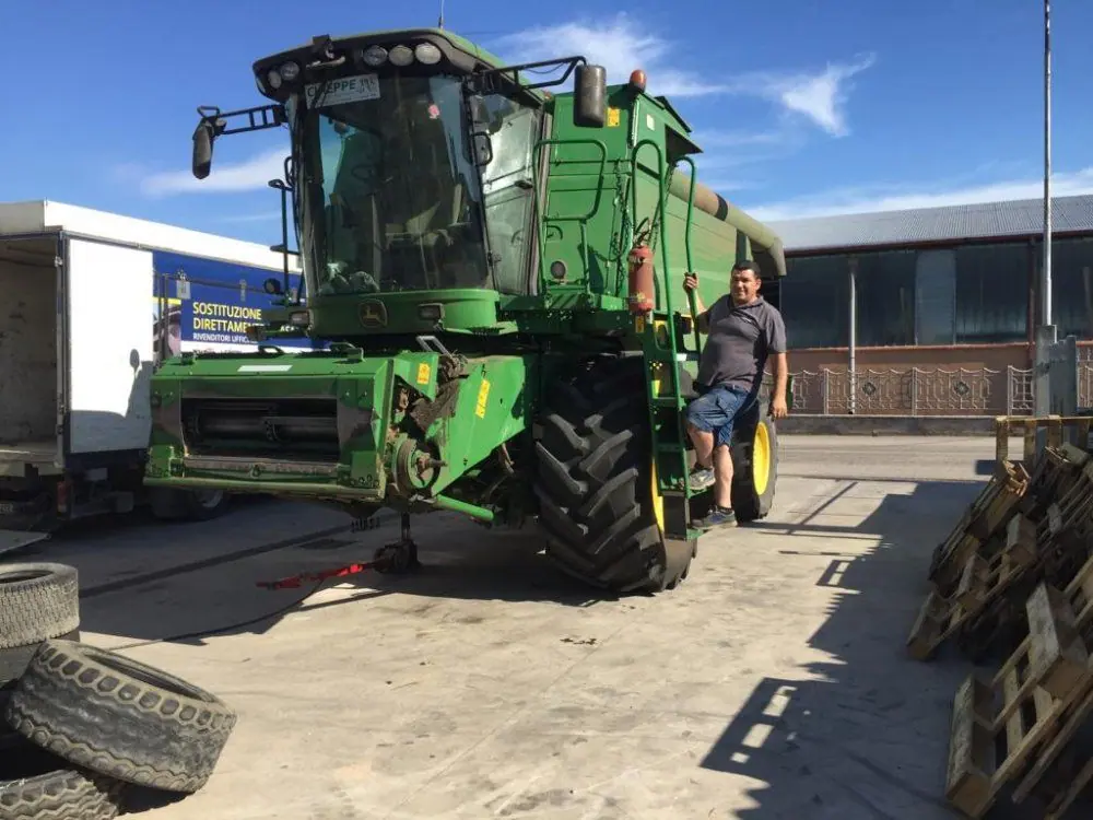 Una mietitrebbia in piazzale, accanto a un tecnico