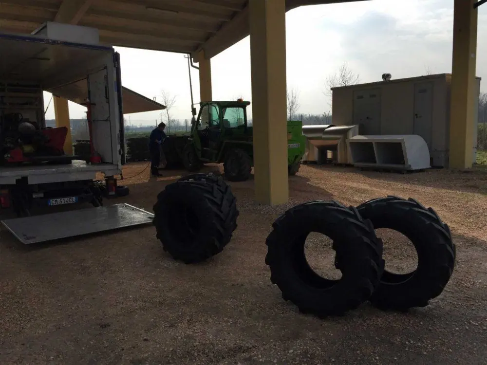 Gomme da trattore a terra sotto una tettoia, accanto all’autocarro di soccorso