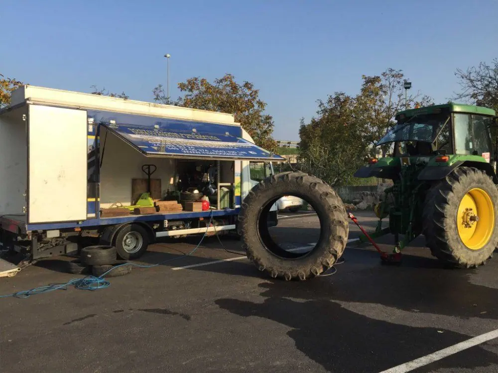 L’autocarro di soccorso con la tenda aperta accanto a un trattore